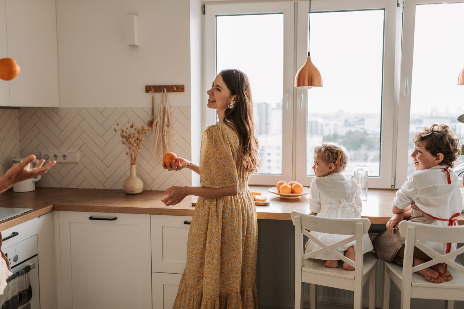 A joyful family bonding in a bright kitchen with oranges and smiles.